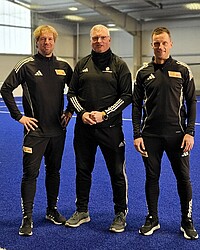 Das Foto zeigt drei Trainer in der Sporthalle, zwei tragen das Logo des 1. FC Union Berlin
